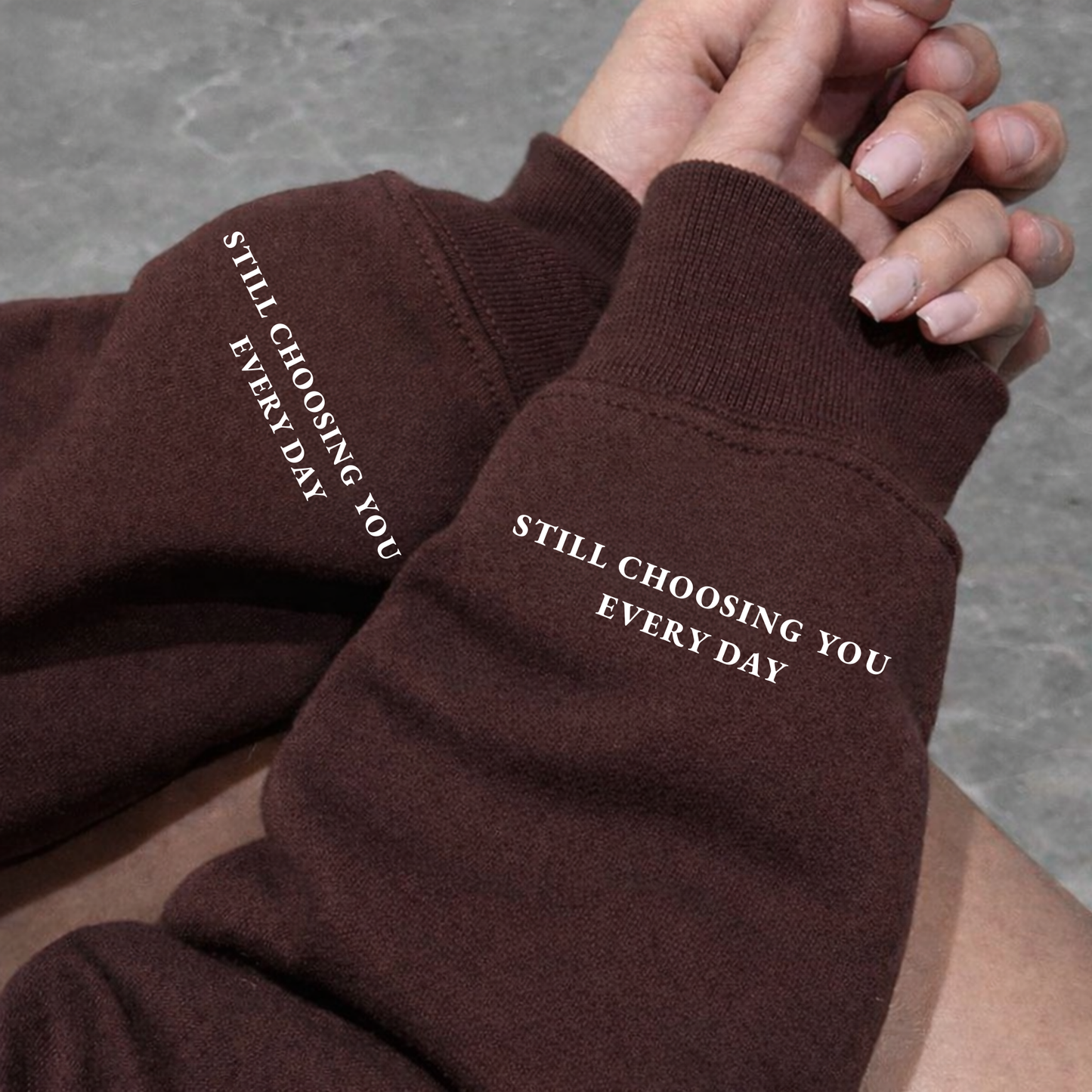 Close-up of Brown Hoodie, Sweatshirt sleeve showing "Still Choosing You Every Day" text printed on left wrist cuff