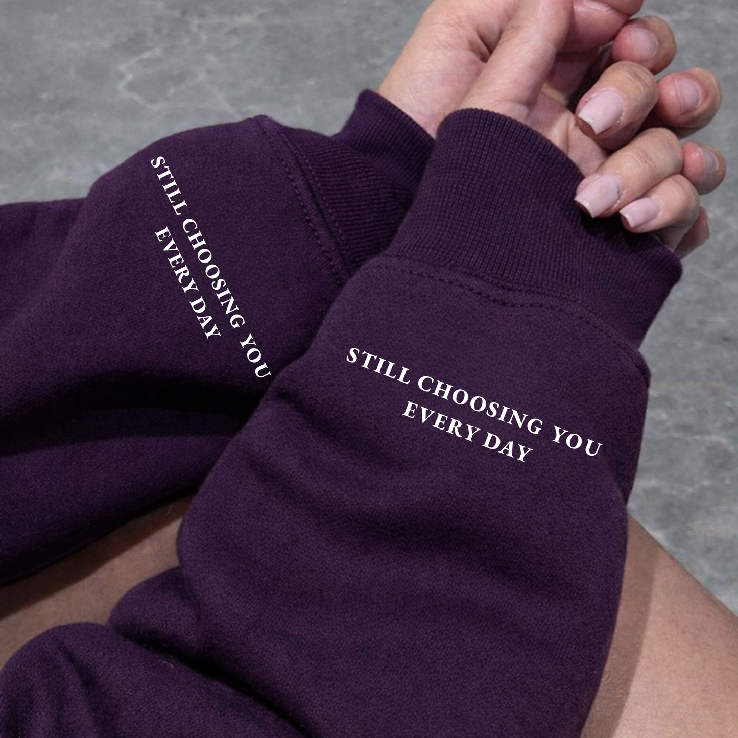 Close-up of Purple Hoodie sleeve showing "Still Choosing You Every Day" text printed on left wrist cuff